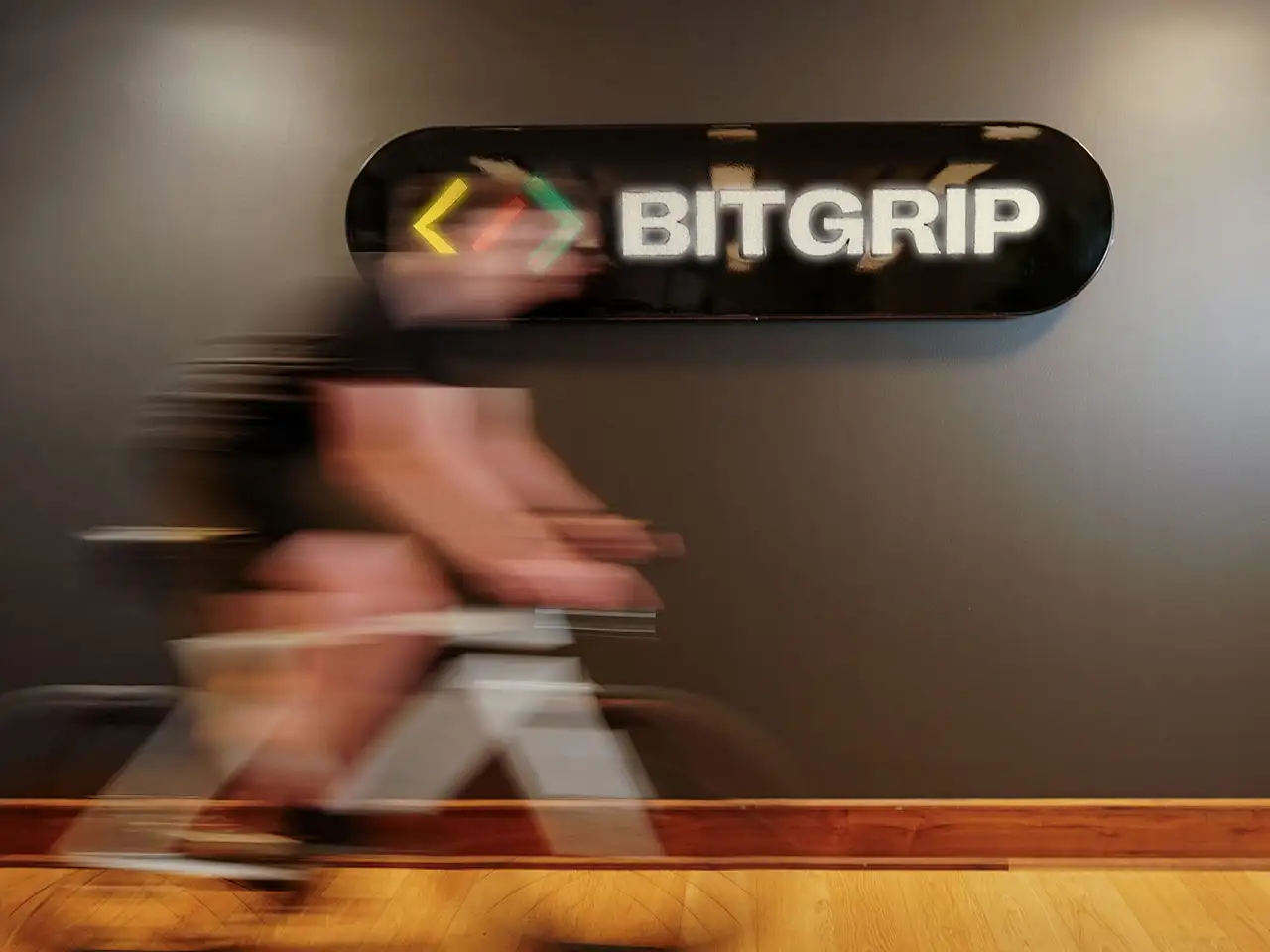 Im Büro von IT-Dienstleister und JobRad-Arbeitgeber BitGrip fährt ein Mitarbeiter vor dem Unternehmens-Logo mit leichter Bewegungsunschärfe. Im Büro von IT-Dienstleister und JobRad-Arbeitgeber BitGrip fährt ein Mitarbeiter vor dem Unternehmens-Logo mit leichter Bewegungsunschärfe.